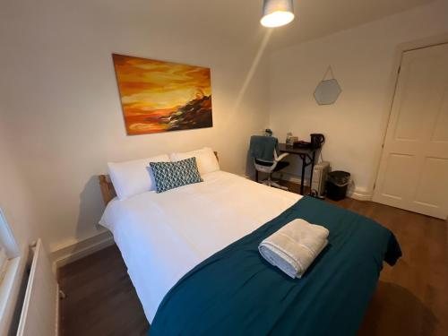 a bedroom with a large white bed with a blue blanket at cozy room in Kent
