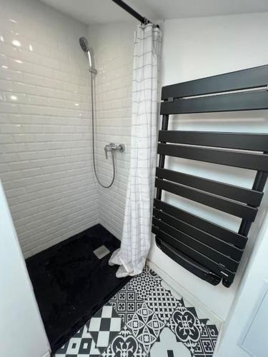 La salle de bains est pourvue d'une douche et de carrelage noir et blanc. dans l'établissement L'Écrin Cosy T2 Hypercentre, à Limoges