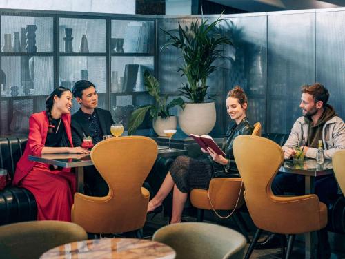 a group of people sitting at a table in a restaurant at Pullman Paris Centre - Bercy in Paris