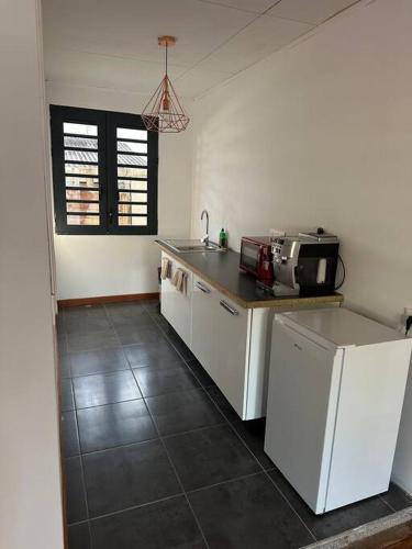 a kitchen with a counter top and a microwave at Studio spacieux in Kourou