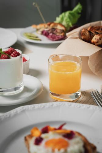 a table with plates of food and a glass of orange juice at Hotel Ca' Bianca in Riccione