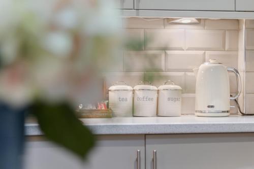 a kitchen counter with four cups and a tea kettle at No 6 - Wisteria Cottage - Pass the Keys in York