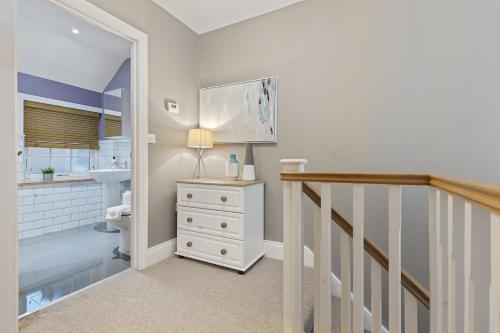 a bathroom with a sink and a toilet and a staircase at No 6 - Wisteria Cottage - Pass the Keys in York