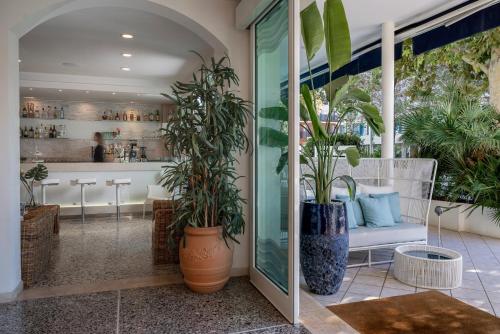 a restaurant with potted plants in the lobby at Hotel Ca' Bianca in Riccione