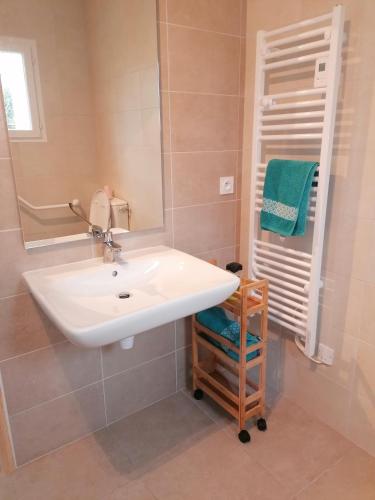 une salle de bain avec un lavabo blanc et un miroir dans l'établissement Logement PMR, chez Nathalie, à Longeville-sur-Mer