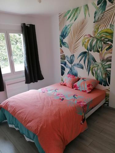 - une chambre avec un lit rouge et un papier peint tropical dans l'établissement Logement PMR, chez Nathalie, à Longeville-sur-Mer