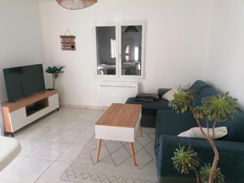 ロンジュヴィル・シュル・メールにあるLogement PMR, chez Nathalieの青いソファとテレビのあるリビングルーム