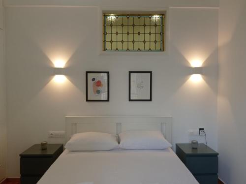 a bedroom with a white bed with two night stands and two lamps at Parthenon retreat in Athens