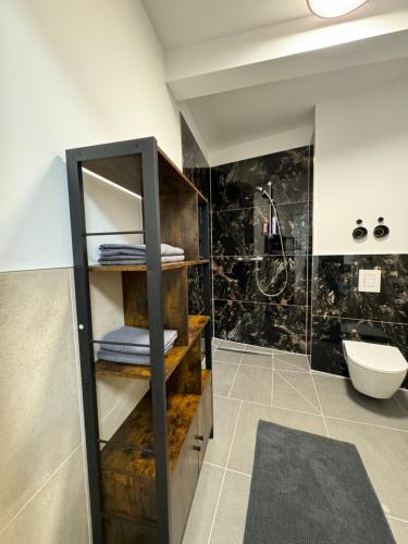 a bathroom with a sink and a shelf with towels at Zeitperlewohnen Petrol in Witten