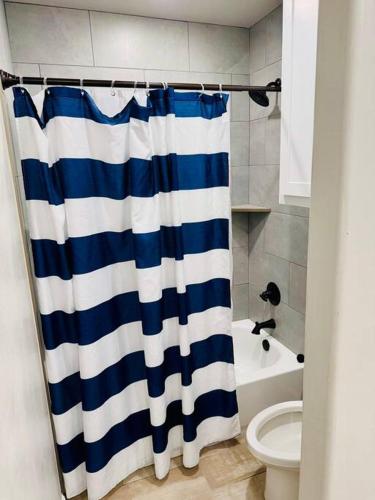 a bathroom with a blue and white shower curtain at Come n find out! Breathtaking! in Lawton