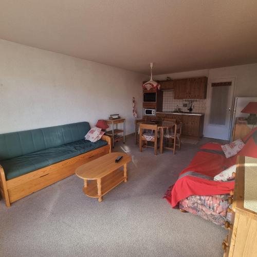 a living room with a couch and a table at Résidence Porthos C2-4pers-Alpe d'Huez-Centre Station in LʼHuez