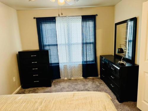 a bedroom with a bed and a dresser and a window at Come n find out! Breathtaking! in Lawton
