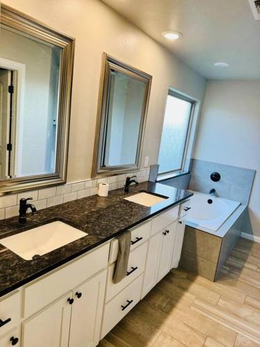 a bathroom with two sinks and a large mirror at Come n find out! Breathtaking! in Lawton