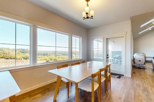 a dining room with a table and chairs and windows at Heaven on Hemlock in Union
