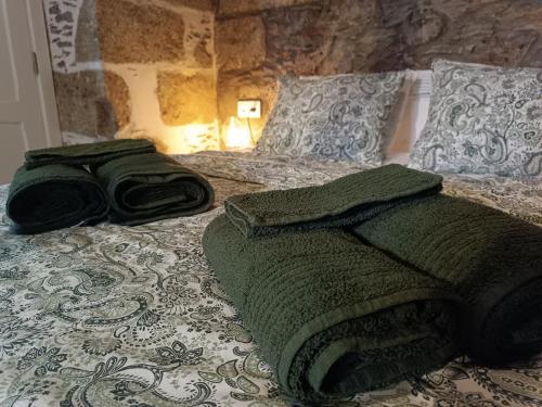 a green towel laying on top of a bed at Casa Bailarina, romantický kamenný dům s úžasným výhledem na oceán in Agaete