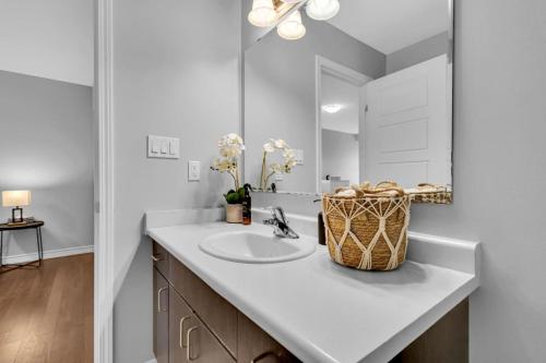 a bathroom with a sink and a mirror at Cozy 3BR Home with Parking Near Kitchener Attractions in Kitchener