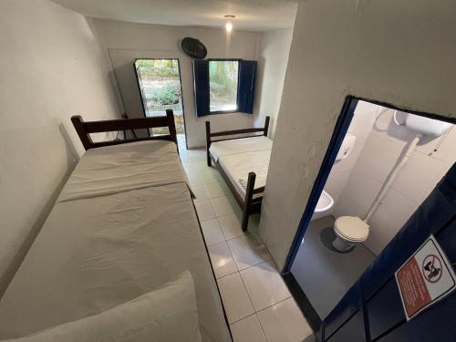 a small room with two beds and a window at Ooxe Hostel in Itacaré