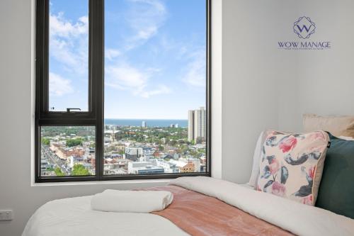 a bedroom with a window with a view of the city at WOW Apartment on Hancock Southbank in Melbourne