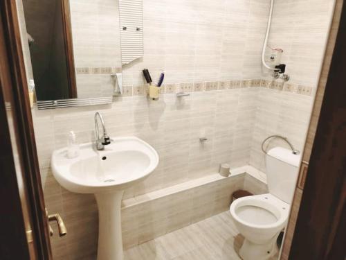 Un baño blanco con lavabo e inodoro. en Sweet Family Home in Yerevan, en Ereván