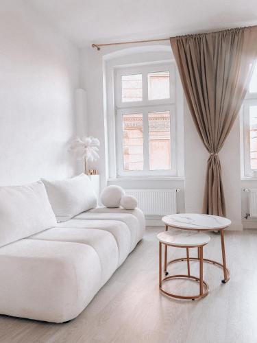 a white living room with a white couch and a table at Złote Apartamenty Kłodzko in Kłodzko