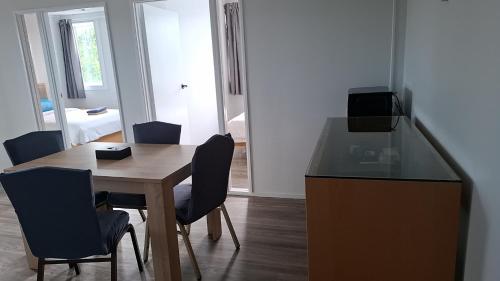 a dining room with a table and chairs in a room at 9 Beds including 3 Double Beds, 4 Single Beds, 2 Sofa Bed, Suite 1, 37 Totara Avenue, New Lynn in Auckland