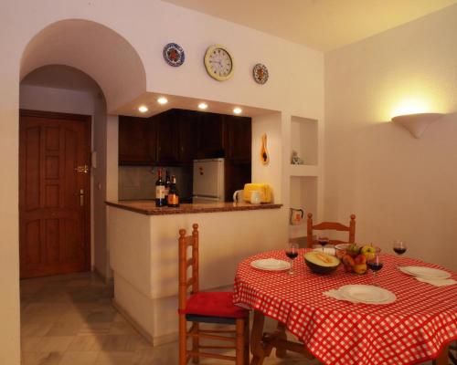 eine Küche mit einem Tisch mit einem roten und weißen Tischtuch in der Unterkunft Sunny apartment Aldea Del Mar near the sea in Torrevieja