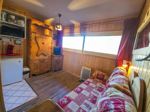 un salon avec un canapé et une cuisine dans l'établissement Appartement cosy aux Menuires, pieds des pistes - FR-1-452-10, aux Menuires