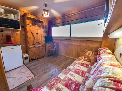 Cette chambre comprend un lit et une grande fenêtre. dans l'établissement Studio style chalet, pied des pistes, Les Menuires, 2 pers., 3 flocons 