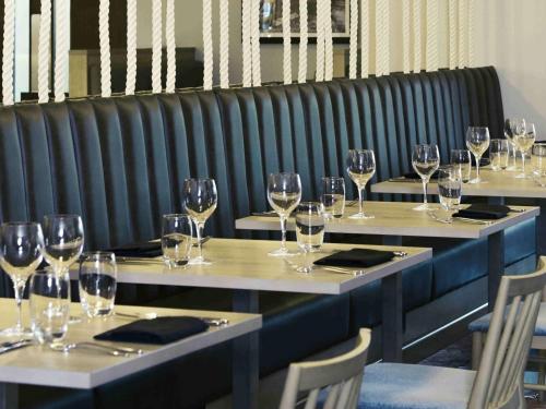 a row of tables with wine glasses on them at Holland House Hotel Cardiff By Sunday in Cardiff