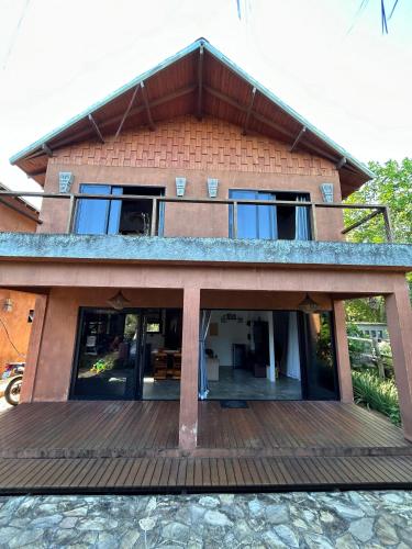 a house with a large deck in front of it at Barong EcoVilla in Barra Grande