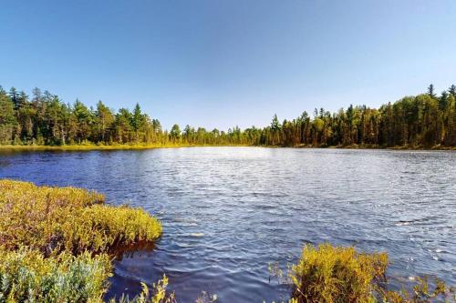 a large lake with trees in the background at Öbois Charlevoix - ÖBox lake view in Saint-Siméon