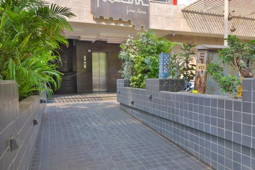 a walkway in front of a building with plants at Hotel The Grand Suites in Ahmedabad