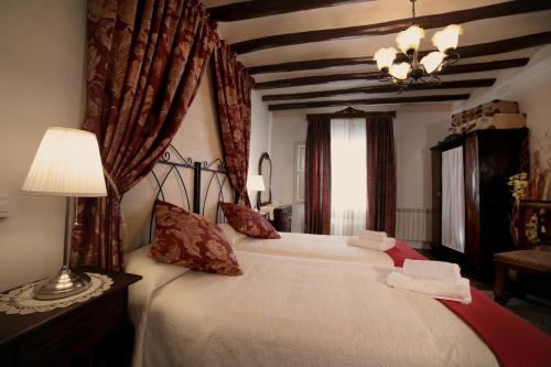 a bedroom with a large bed with red curtains at Casa Rural La Casona in Urrea de Gaen