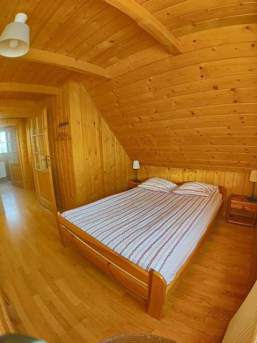 a bedroom with a bed in a wooden room at Osada Koniówka in Koniówka