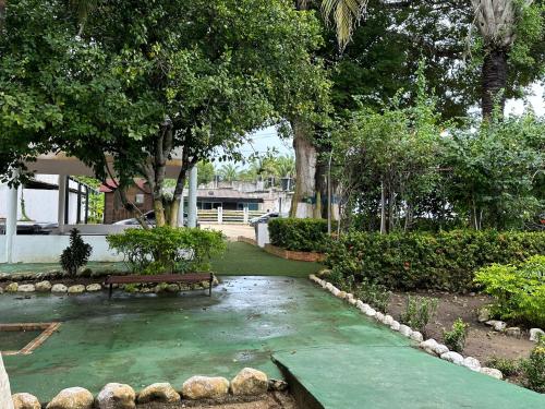 a park with a bench and trees and a house at Apartamento en Coveñas cómodo y acogedor in Coveñas