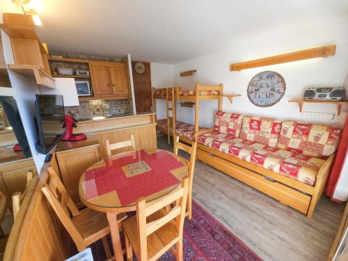 Cette petite chambre comprend une table et des lits superposés. dans l'établissement Studio skis aux pieds aux Menuires pour 3 personnes, balcon et casier à skis - FR-1-452-3, aux Menuires