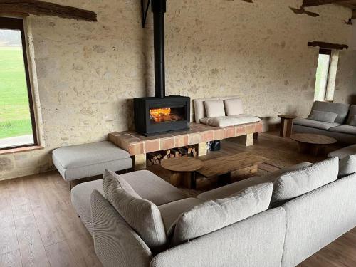 a living room with a couch and a fireplace at Gîte L'Etable - Domaine Lassalle Saint-créac in Saint-Créac