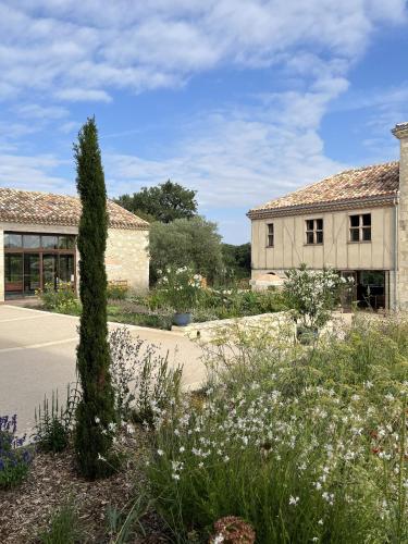 a garden with flowers in front of a building at Gîte L'Etable - Domaine Lassalle Saint-créac in Saint-Créac