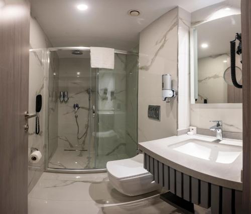 a bathroom with a shower and a toilet and a sink at Icon Hotel Bomonti in Istanbul