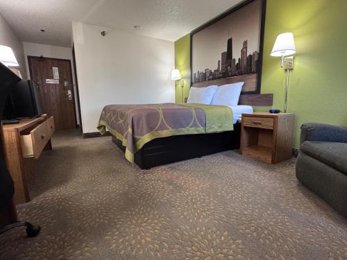 a hotel room with a bed and a couch at Super 8 by Wyndham Mokena/Frankfort /I-80 in Mokena