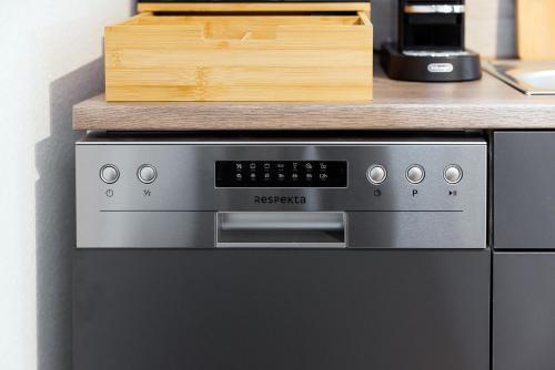a microwave oven with a wooden box on top of it at VISTAMO Dorsten-Rhade, modernes Apartment in Dorsten