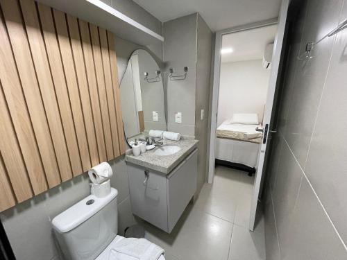 a bathroom with a toilet and a sink and a mirror at Sunny Hall by AFT in Porto De Galinhas