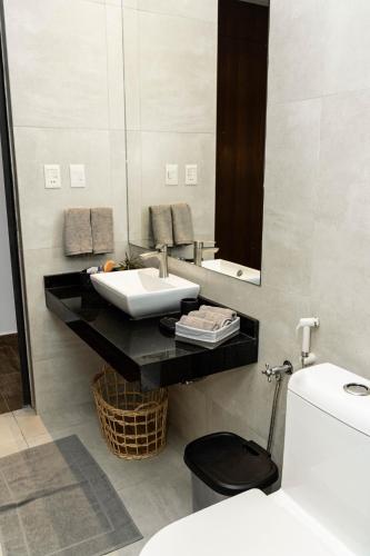 a bathroom with a sink and a mirror and a toilet at Spacious apartment with Style and Natural Light in Asunción