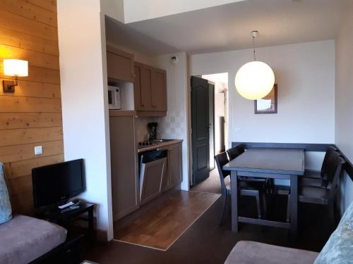 Il comprend un petit salon avec une cuisine et une table. dans l'établissement Résidence La Marelle et Le Rami - maeva Home - Appartement 3 pièces 7 personnes - Sélection MAE-3194, à La Plagne Tarentaise