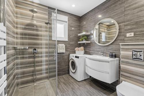 Un baño con lavadora y lavabo. en Villa Matan - only 200m from the sandy beaches, private 28m2 pool, en Omiš