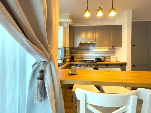 a kitchen with a table with chairs and a curtain at Lumial Mountain Nest in Braşov