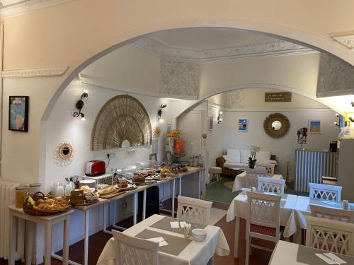 a dining room with tables and chairs and an archway at Logis Hôtel Villa Victorine in Nice