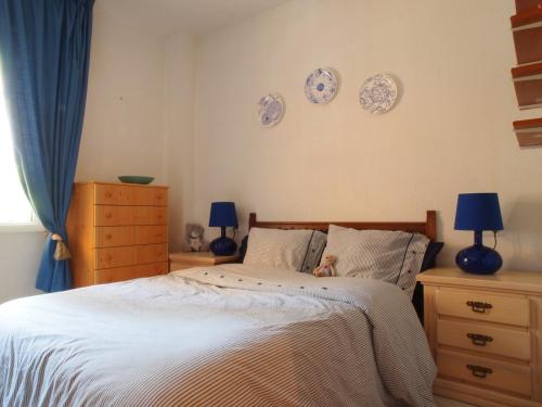 ein Schlafzimmer mit einem Bett mit Platten an der Wand in der Unterkunft Sunny apartment Aldea Del Mar near the sea in Torrevieja