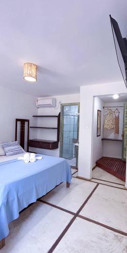 a white room with a bed and a mirror at Casarão Jeri in Jericoacoara