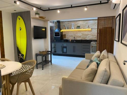 a living room with a couch and a surfboard on the wall at Casa em Juquehy flat 02 in São Sebastião